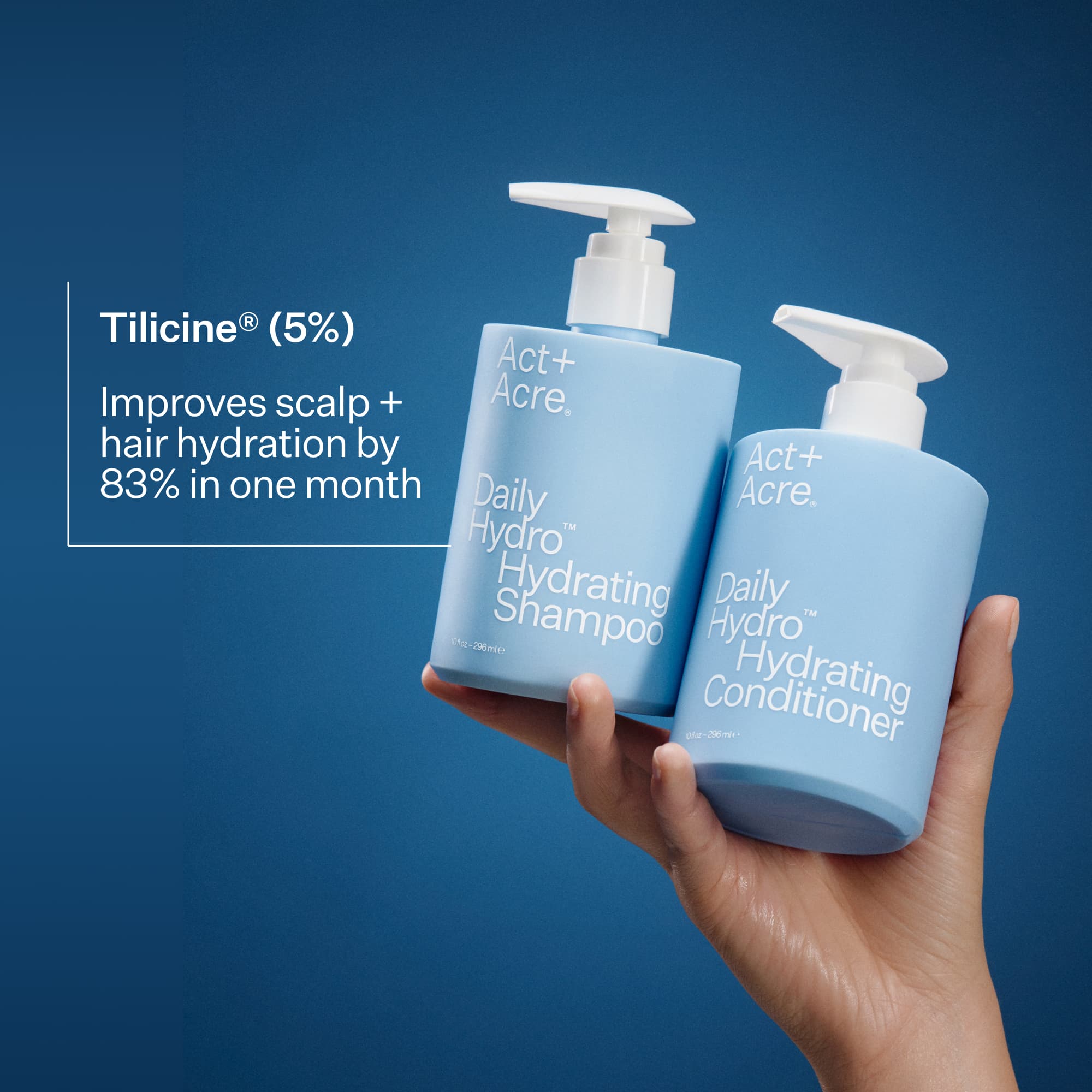 Hand holding a bottle of Daily Hydro™ Hydrating Shampoo and Conditioner with a blue background